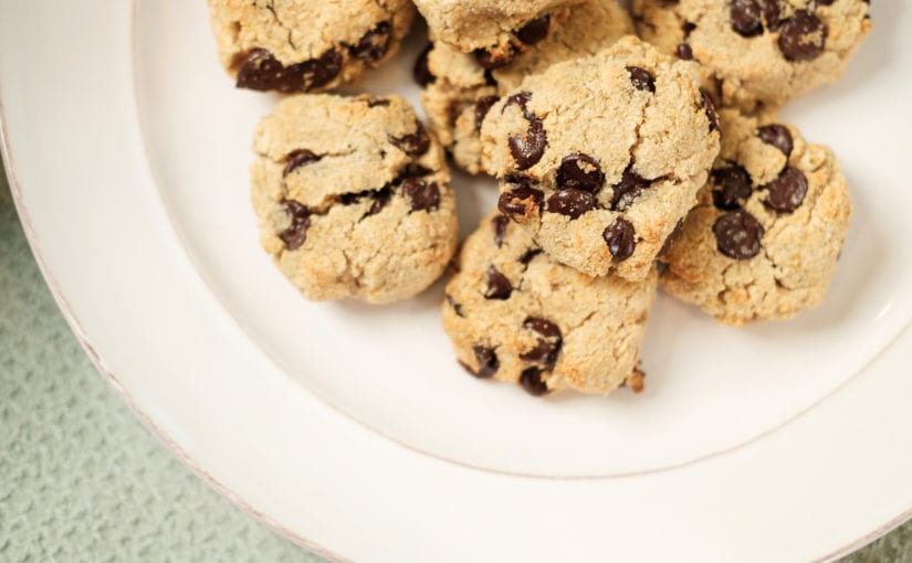 White glass plate with a bunch of chocolate chip cookies on them.