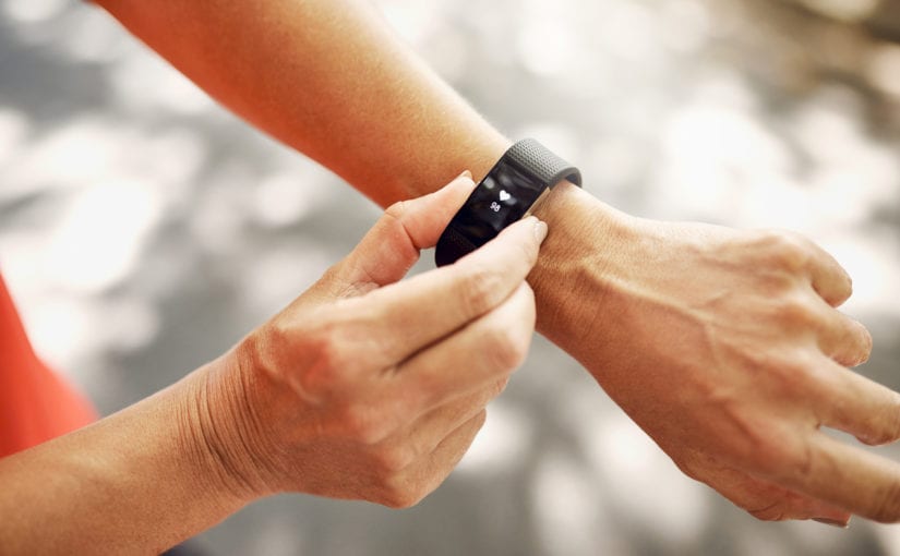 Woman hands showing her black smart watch.